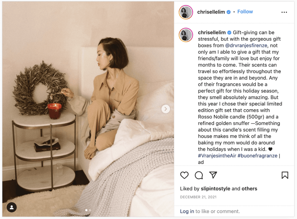 This social media post shows an influencer promoting a brand's candles in bed and is an example of holiday marketing. 